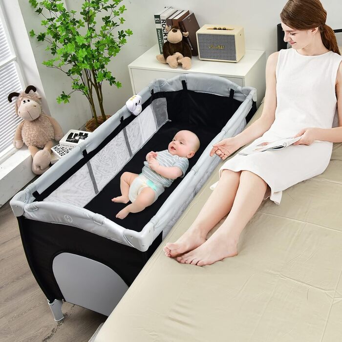 Складане дорожнє ліжечко COSTWAY 4-в-1, дитяча колиска, пеленальний столик та манеж з функцією гойдання, включаючи музичний мобіль, ігрову арку, пеленальний килимок, матрац, органайзер для підгузків та сумку для перенесення (чорний)
