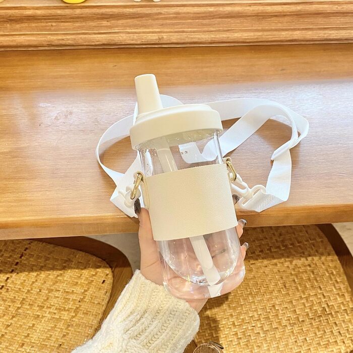 Чашка для пиття з плечовим ременем. Практична пляшка для води зі знімною трубочкою. Виготовлена з пластику. Для любителів напоїв. З плечовим ременем.