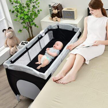 Складане дорожнє ліжечко COSTWAY 4-в-1, дитяча колиска, пеленальний столик та манеж з функцією гойдання, включаючи музичний мобіль, ігрову арку, пеленальний килимок, матрац, органайзер для підгузків та сумку для перенесення (чорний)